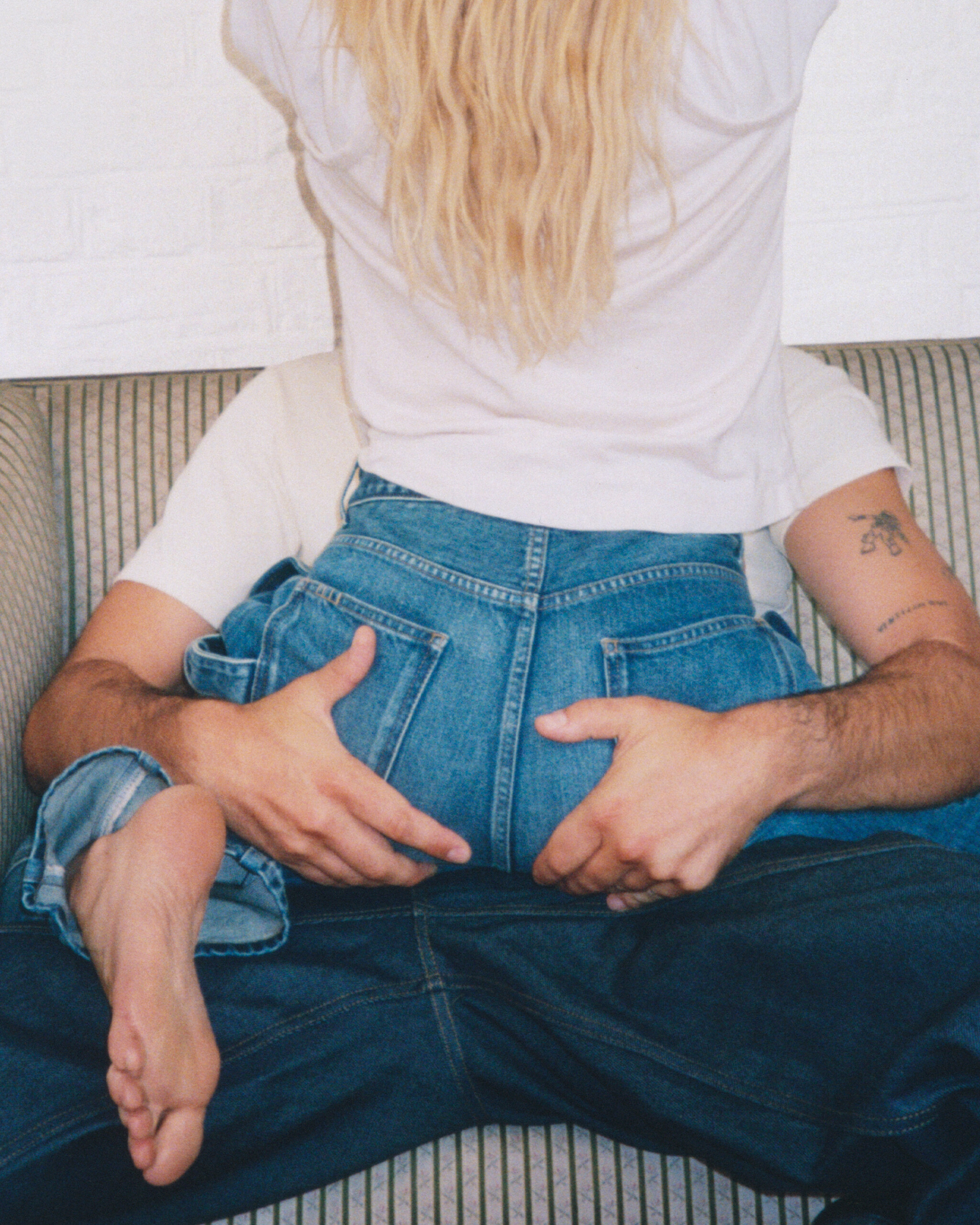 Detail of JW Anderson Twisted Denim back pockets and seaming on a striped settee