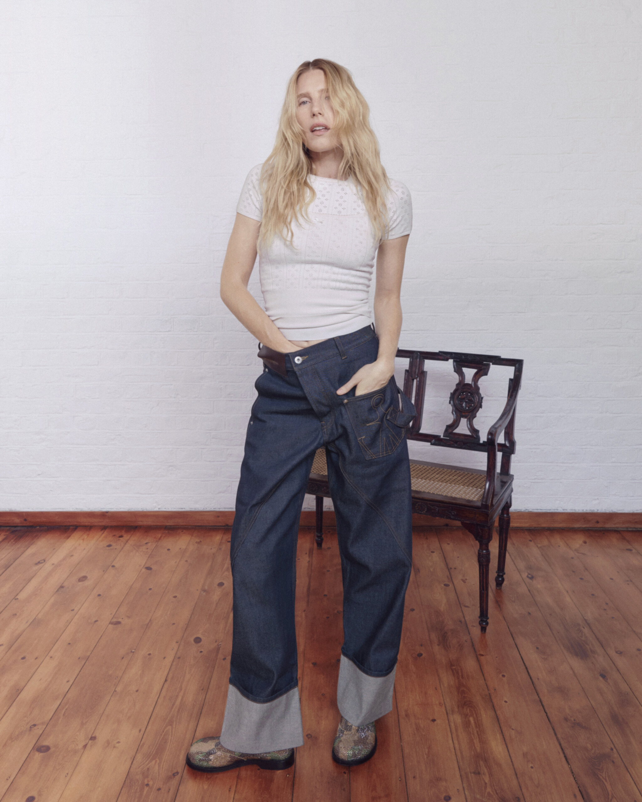 Dree Hemingway in raw indigo JW Anderson Twisted Denim with grey turned-up cuffs