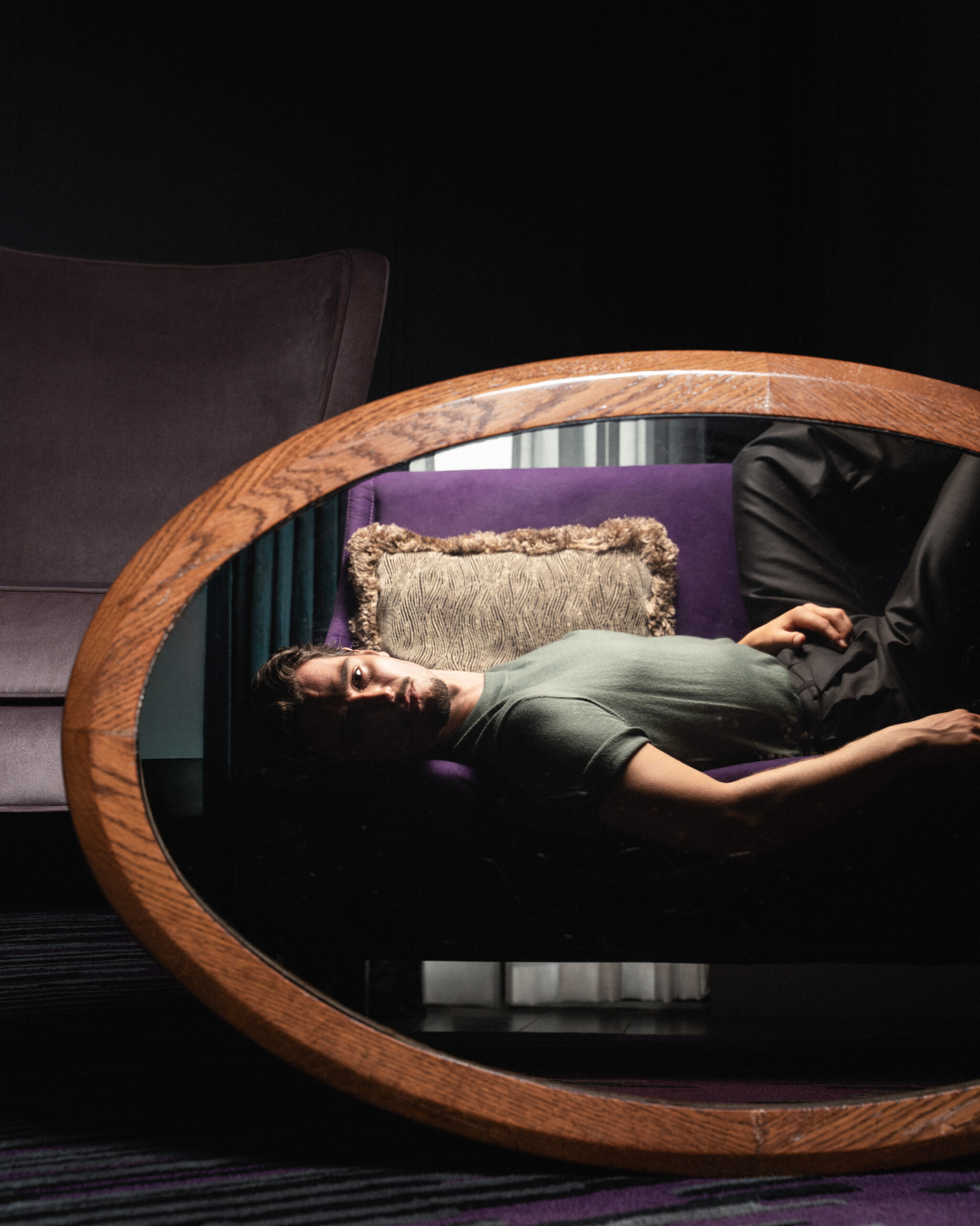 Jack Brett Anderson reflected in an oval mirror in a suite at The Mandrake, London